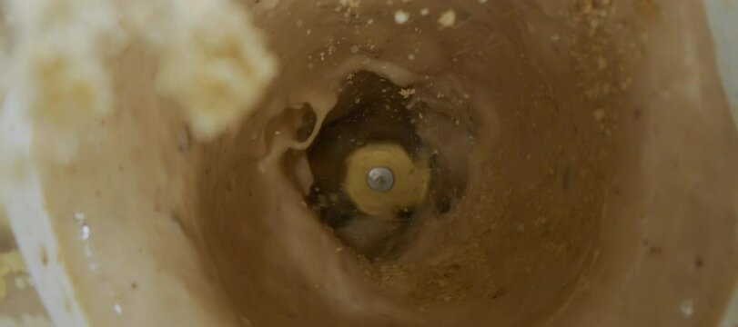 Super slow-motion shot of serving protein powder into the blender. Process of delicious making milk smoothie