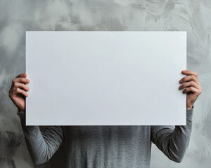 Blank White Sign Held by Person in Gray Shirt Against Textured Wall Background - Perfect for Custom Message or Branding in Lifestyle Photography