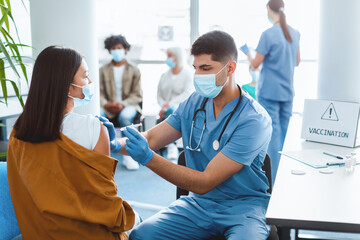 Mass Immunization, Prevention Procedure Concept. Young Asian Lady In Surgical Mask Receiving...