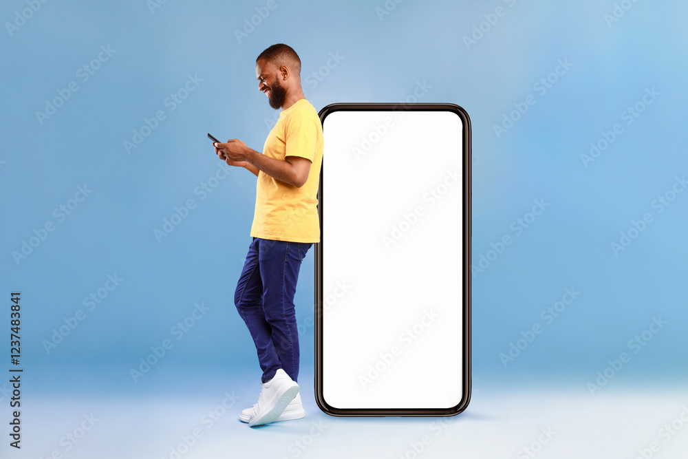 Aufkleber full length of young african american guy using cellphone while leaning on giant mobile phone with e