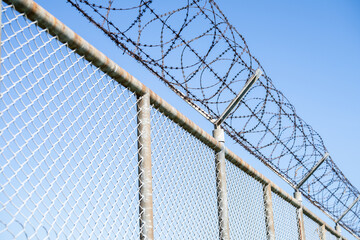 Prison security fence. Barbed wire security fence. Razor wire jail fence. Barrier border. Boundary...