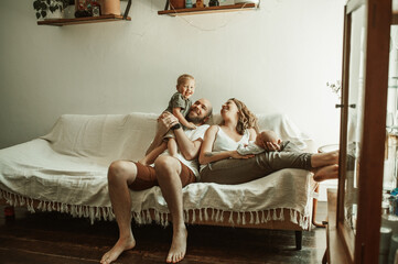 Parents, children and a family laughing on the sofa in the living room of their home together for...