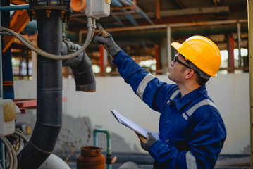 A plumbing inspector is inspecting the operation of a high-pressure water pump system in an industrial plant to ensure compliance with required standards.