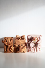 Gift boxes wrapped in reusable fabric, promoting waste reduction and sustainable gifting ideas.