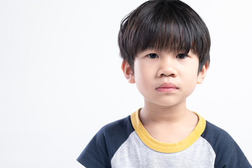 A young Thai boy with a serious expression looks directly at the camera against a white background.