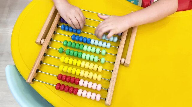 Child Using Wooden Abacus in Thailand