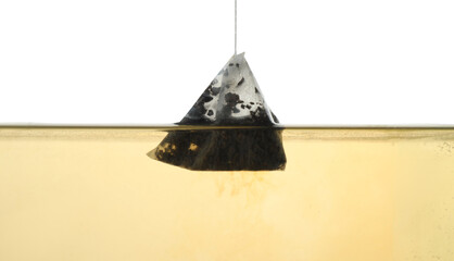 Putting tea bag into glass cup on white background, closeup