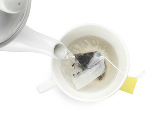Pouring hot water into cup with tea bag on white background, top view