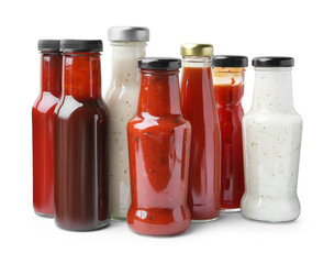 Different delicious sauces in glass bottles isolated on white