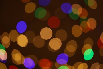 Blurred view of colorful lights on dark background, bokeh effect