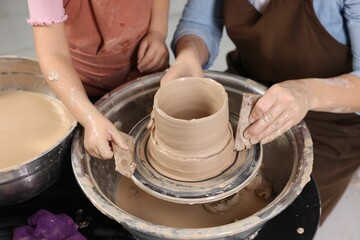 Hobby and craft. Mother with her daughter making pottery indoors, closeup