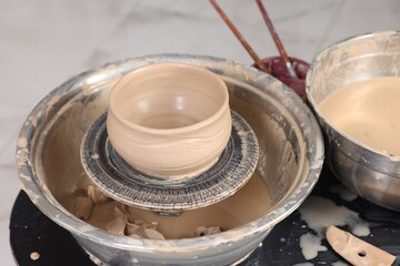 Hobby and craft. Beautiful bowl on potter's wheel in workshop, closeup