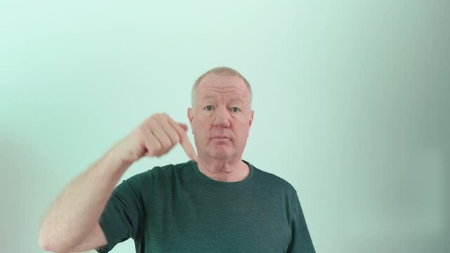 Senior man pointing down for social media content asking to subscribe, like, or leave a comment