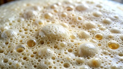 The surface of the sourdough bread dough starter is covered in a dense network of small bubbles and a fine layer of foam, indicating active fermentation , kitchen, microorganisms