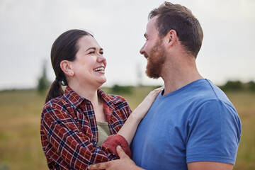 Obraz premium Outdoor, couple and happy with love in farm, sustainable environment and agro field with bonding. Countryside, man and woman with affection embrace for admiration, agriculture and farmer in Australia
