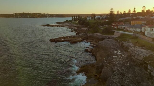 Aerial drone view along Cronulla Beach Walk heading toward Oak Park in Cronulla in the Sutherland Shire, South Sydney, NSW Australia during late afternoon summer in February 2025   