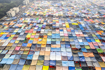 Festival ground where people have put up colorful tents to protect from the sun and the hea