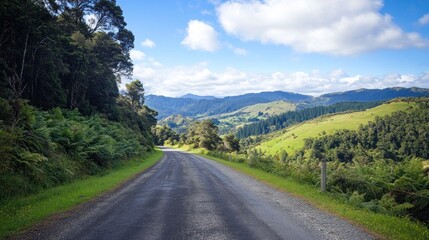 Naklejka premium Scenic country road winding through lush green hills