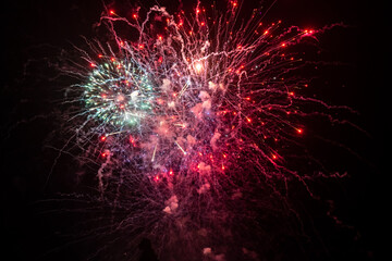 Holiday fireworks explode in the night sky. Selective focus. 