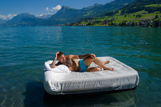 Sexy man resting on the infinity mattress in summer lake water. Traveler enjoying a summer. Muscular guy rest in clear sea or ocean water. Sexy male model sunbathing on a summer. Hot summer.