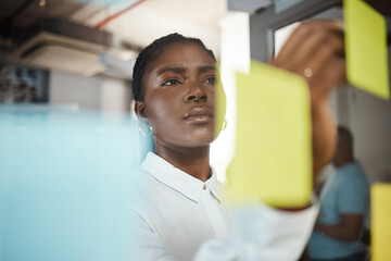 Office, black woman and writing with sticky note for planning, brainstorming session and writer....