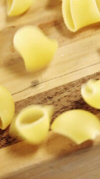 Raw pasta falling on chopping board