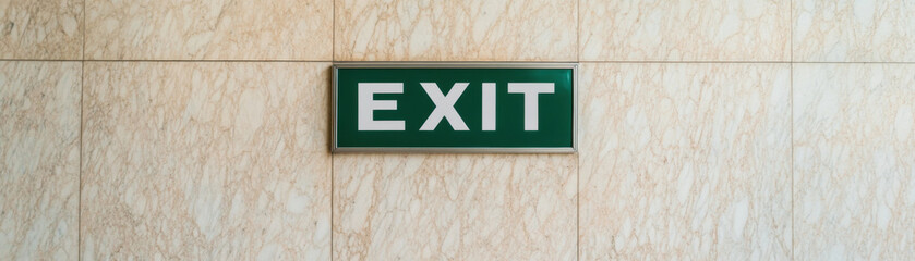 Minimalist green exit sign with bold white typography on marble wall, providing clear direction and enhancing safety in public spaces