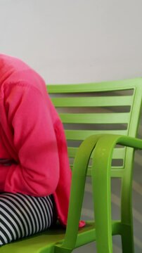 Upset girl sitting on chair in hospital corridor