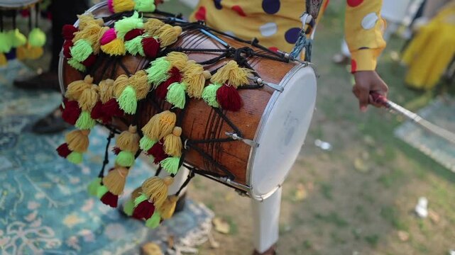 A shot of a man playing dhol at an Indian Wedding function in India
