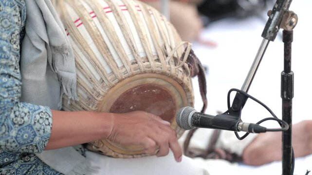 Shot of a musician playing dholak at an Indian Wedding function in India
