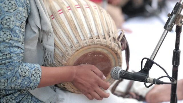 Shot of a musician playing dholak at an Indian Wedding function in India
