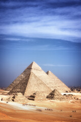 pyramids of giza, Cairo, Egypt; with camels and tourists, desert and clear sky.
