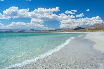 The beach is covered with golden sand, and the blue sky in summer has white clouds floating on it. The sun shines brightly over crystal-clear turquoise water. 