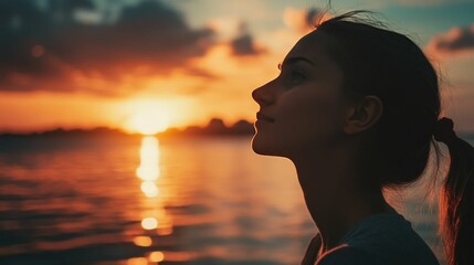 Silhouette of woman looking at sunset over ocean