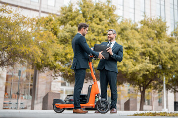Two business men talking outdoors. Two diverse businessmen talking together. Colleagues discussing and thinking about project. Walking and talking between two business men.