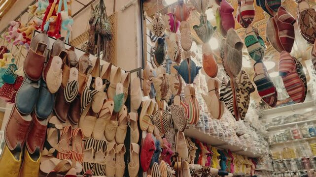 Colorful Moroccan slippers displayed in a traditional market. The vibrant craftsmanship and diverse patterns create a visually appealing scene, showcasing the rich culture of Moroccan artistry.