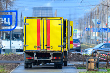 Yellow emergency service car in selective focus on one of the city streets.Сar rescuers near the housе. Gas service.