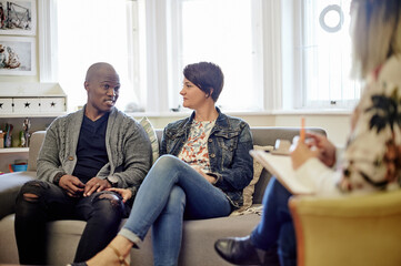 Psychology, sofa and couple talking to a therapist in her modern office at counseling clinic....