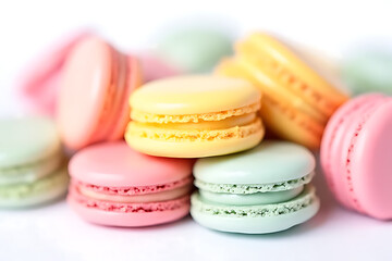 Obraz premium Colorful macaroons stacked on a wooden table with a delicious assortment of pink, yellow, green, and white flavors