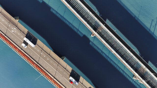 Aerial drone view of bridges across Maas river, railway and automobile road bridge with bicycle lane from above, water background, transportation and infrastructure, Venlo, the Netherlands
