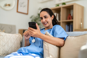 Female doctor using smartphone for remote work, conducting video call consultation to provide...