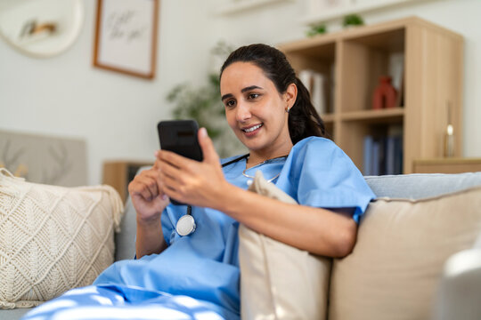 Female doctor using smartphone for remote work, conducting video call consultation to provide health advice and telemedicine services for patient at home, online medical care, diagnosis and treatment
