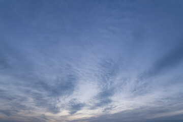 soft blue sky with textured clouds at dawn  
