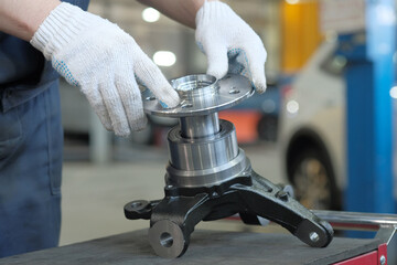 Car service.An auto mechanic performs suspension repairs.On the desktop is the preparation and...