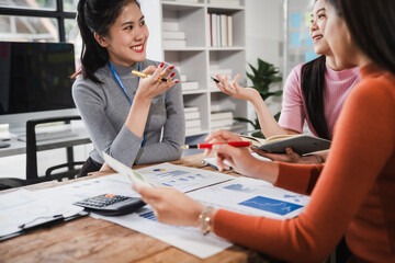 Asian people, motivated businesswoman at her desk, brainstorming creative ideas to kickstart her...