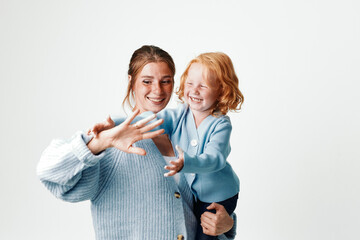 Mother and daughter making sign language for five while traveling together in a foreign country