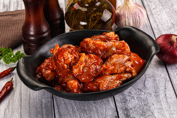 Raw marinated buffalo chicken wings