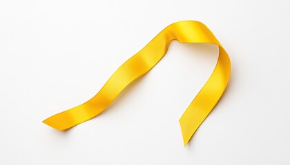 Bright yellow ribbon gracefully draped on a white background, ideal for celebration and gift wrapping