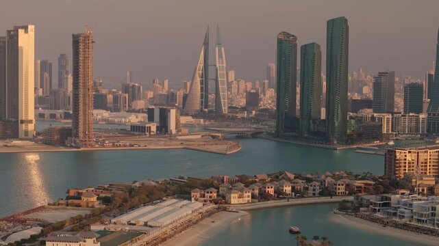 Bahrain, aerial view over luxury waterside condos towards skyscrapers and downtown Manama, warm late afternoon light