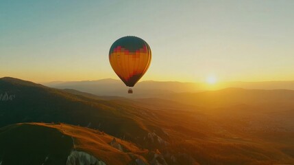 Fototapeta premium Colorful Hot Air Balloon Rising Over Mountain Landscape